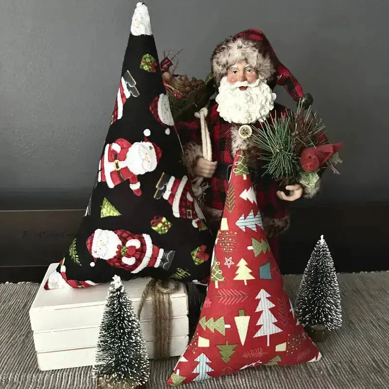 The 2 Christmas trees, made from this sewing pattern, are sitting on top of a dining room buffet with a Santa behind them.