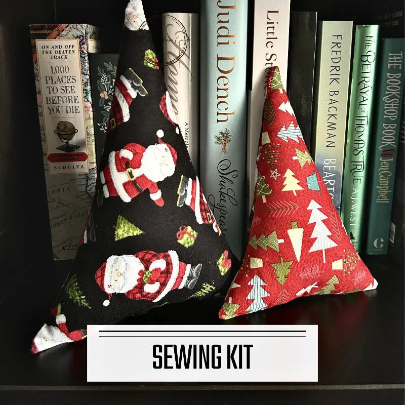 A DIY sewing kit for a set of 2 Christmas trees. The 2 finished trees are sitting on a bookshelf.