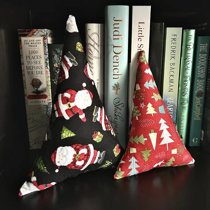 The 2 Christmas trees, made from this sewing pattern, are sitting on a bookshelf.