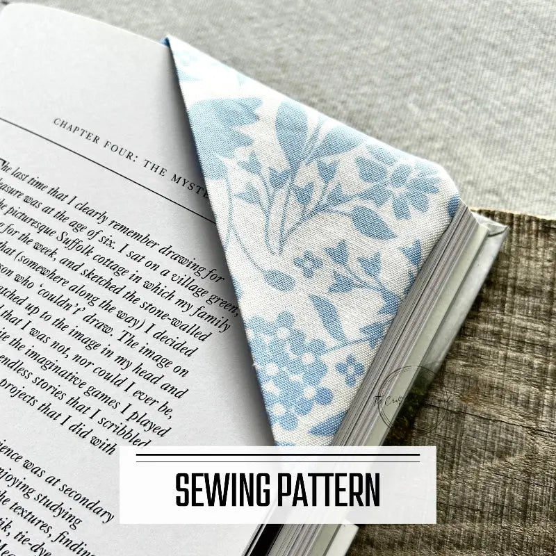 A digital PDF sewing pattern for a corner bookmark. The bookmark is tucked over pages in a book.
