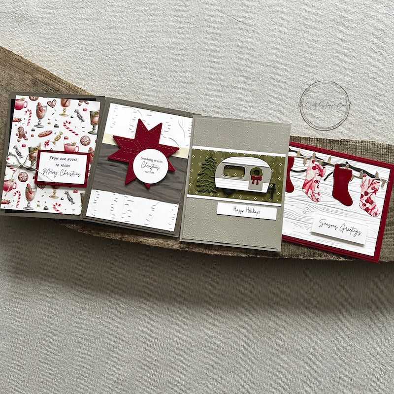 There are 4 finished cards, sitting on a wooden board, to show the finished cards that are included in this kit - The Craft Shoppe Canada