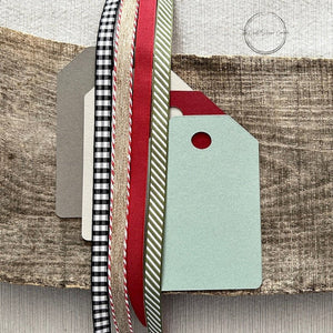 All of the tag pieces are lying on top of tags with ribbons. Everything comes cut and ready for assembly - The Craft Shoppe Canada