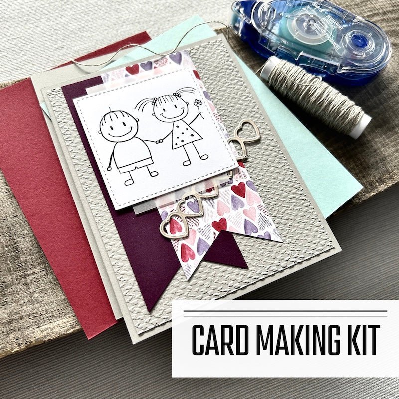 A DIY greeting card kit for Valentine's Day, or an anniversary. A finished card is sitting on blank cards with a roll of twine and a tape runner - The Craft Shoppe Canada 