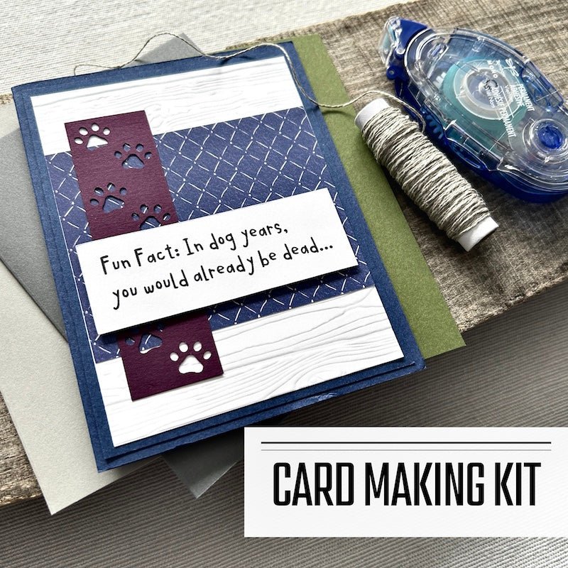 A DIY greeting card kit for birthday cards with funny sentiments. A finished card is sitting on blank cards with a roll of twine and a tape runner - The Craft Shoppe Canada 