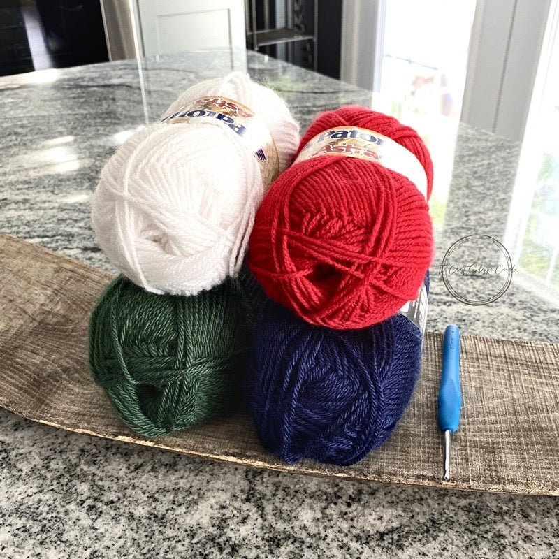 This photo showcases the yarn that was used including the colours red, white, blue and green - The Craft Shoppe Canada