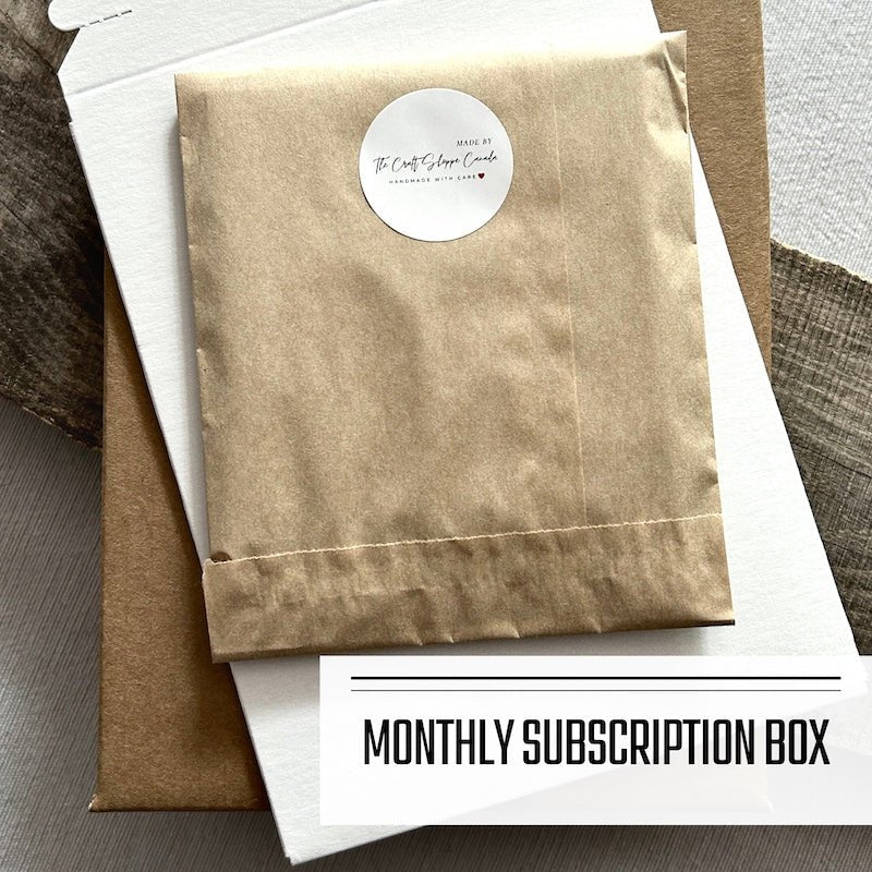 A DIY greeting card kit featuring a wrapped up package of cards that are lying on top of a shipping envelope.