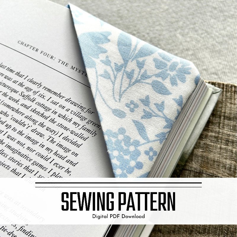 A digital sewing pattern for a corner bookmark. The bookmark is tucked over pages in a book - The Craft Shoppe Canada