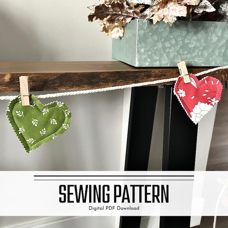 A digital sewing pattern for a valentine heart garland. The garland is hung over a table with flowers - The Craft Shoppe Canada